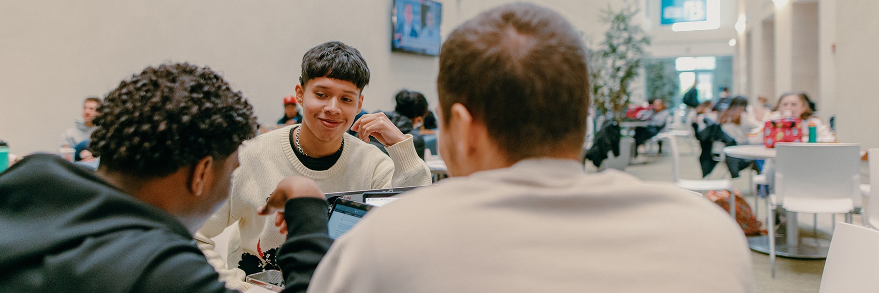 Three students study at table together in Campus Center.