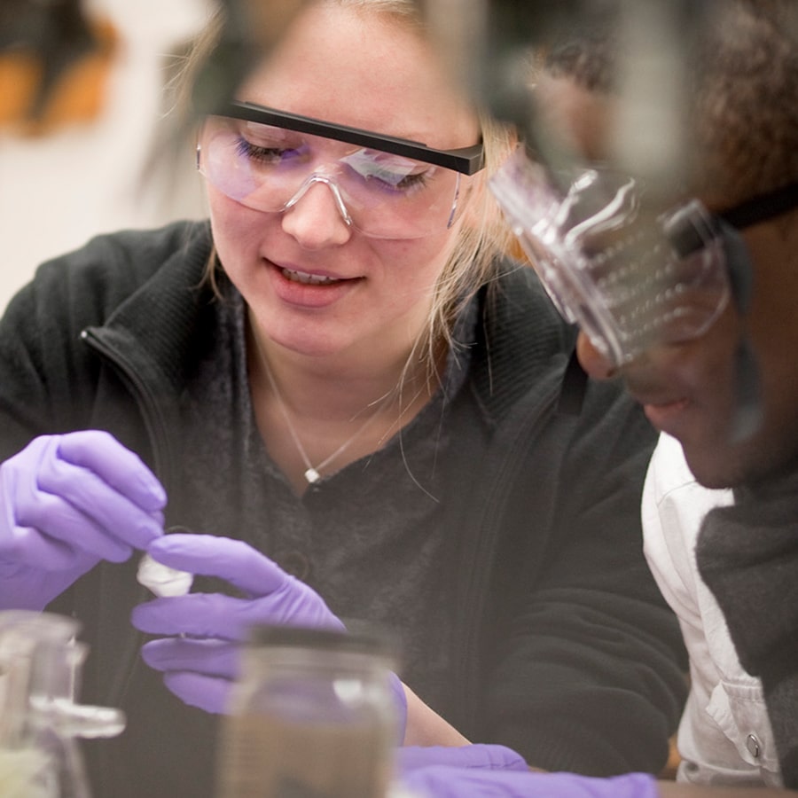 Students in gloves & goggles work on project.