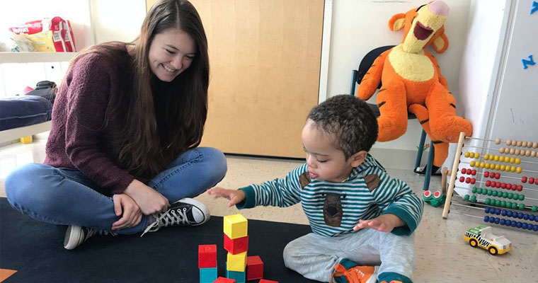 Undergrad Elicia Kelley interacts with a toddler in the Baby Lab