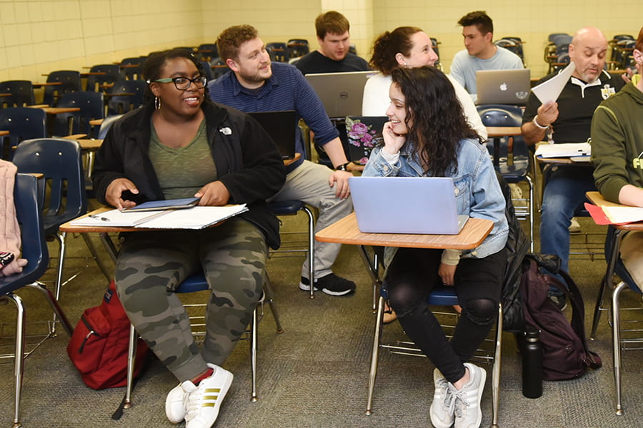 education students sitting in a classroom talking to each other