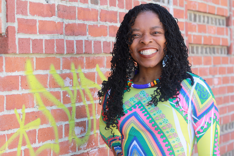 Shaumba-Yandje standing next to a brick wall