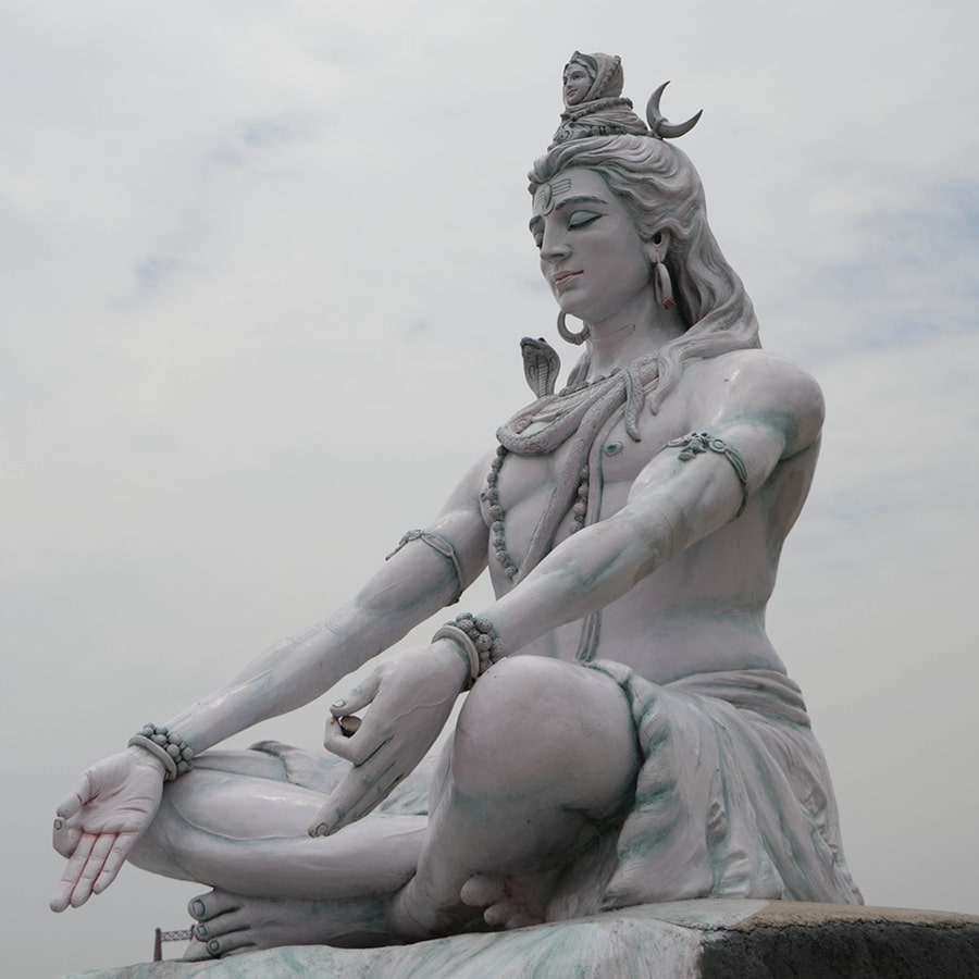 Statue of Shiva, Hindu idol near Ganges River water, Rishikesh, India. The first Hindu God Shiva. Sacred places for pilgrims in Rishikesh - stock photo