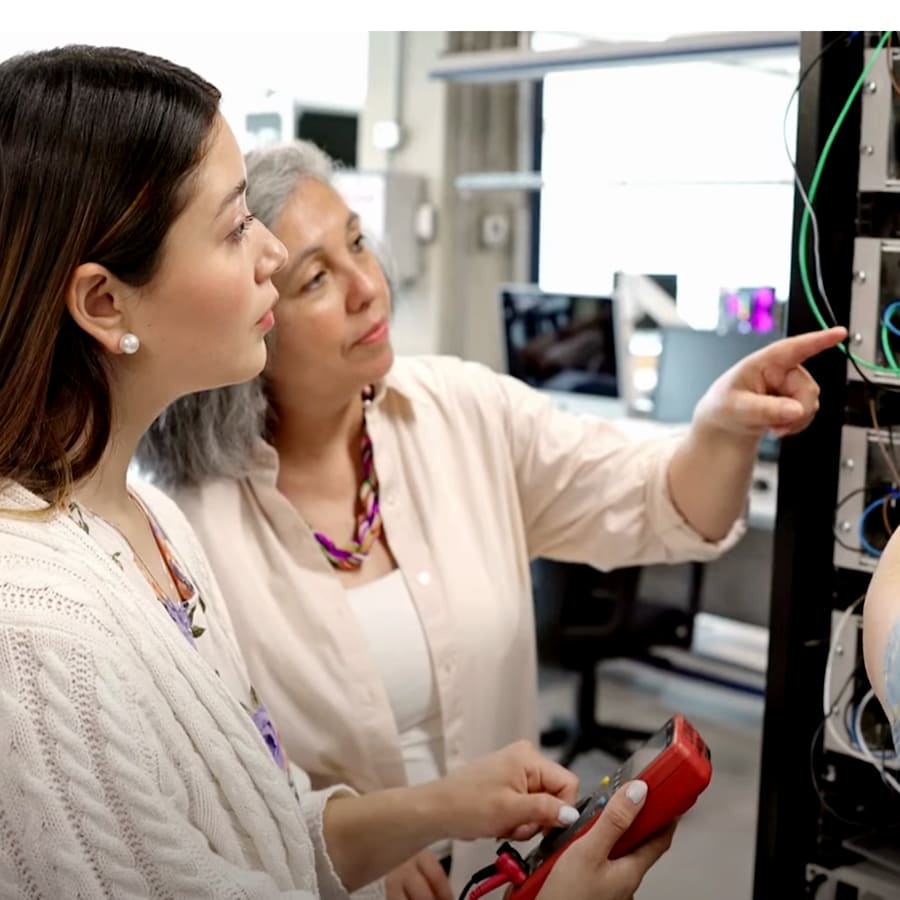 Two women look at equipment.