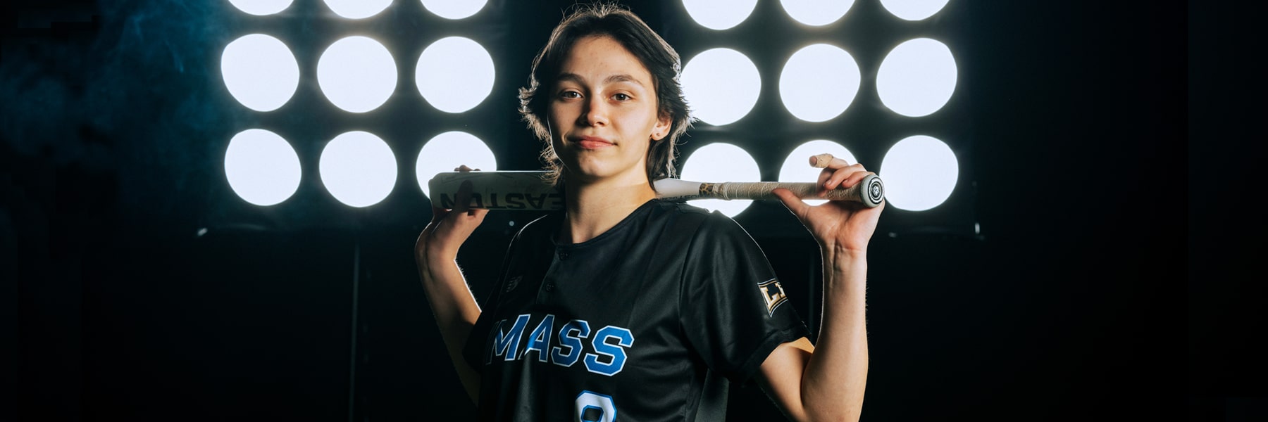 stylistic photo of softball player holding bat behind shoulders