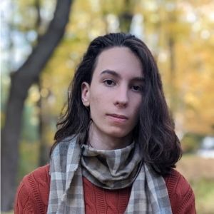 Man with long hair, gray scarf, red sweater